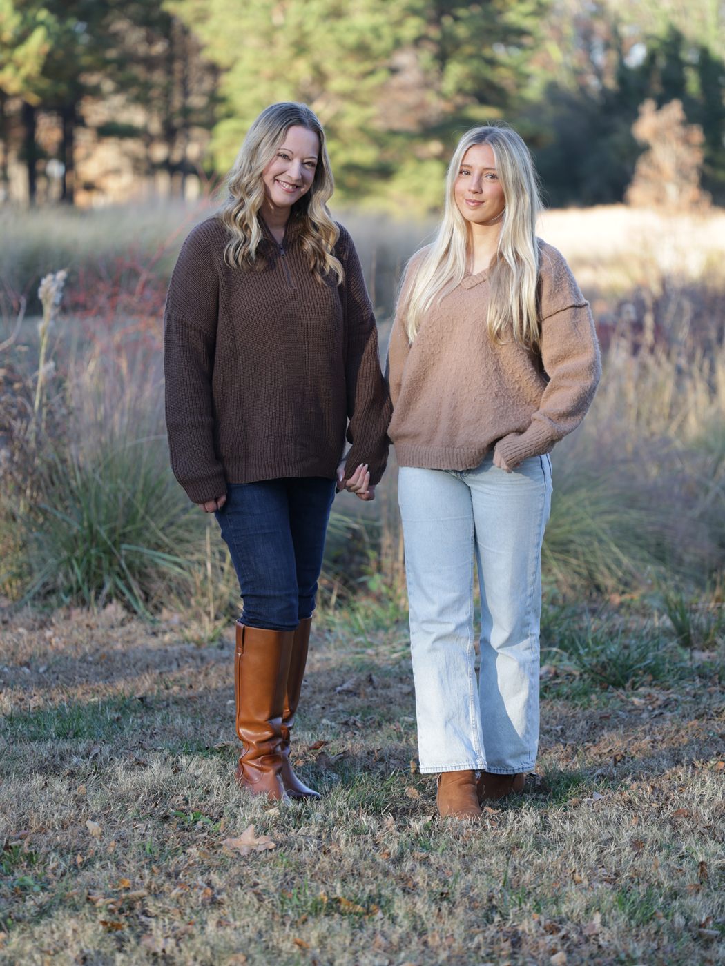 Amanda and Ally Weinraub, the mother and daughter team behind Signature Porch Decor, standing together in a field of autumn grasses